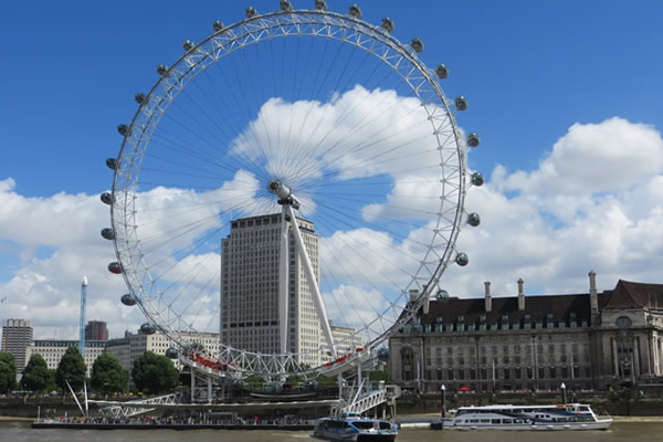 Ferris wheel photo with a clear sky and white clouds