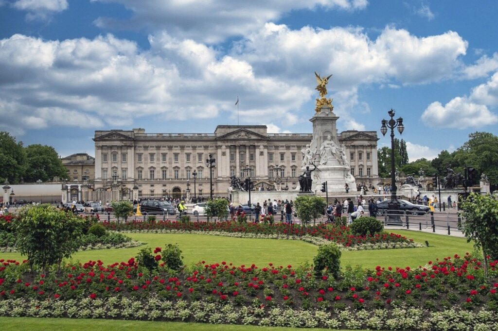 Front face of Buckingham Palace with statue and gardens