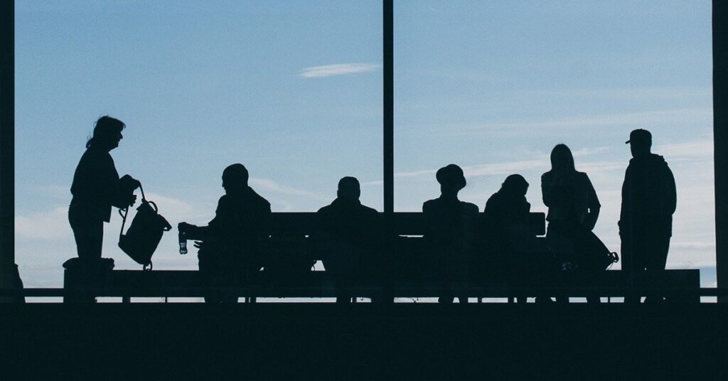 Silhouette of travellers in airport terminal.